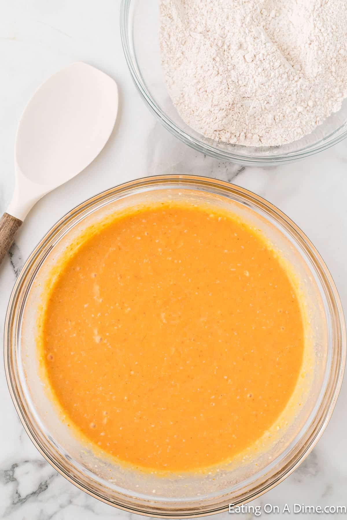 Combining milk, eggs, vanilla, and pumpkin puree in a bowl