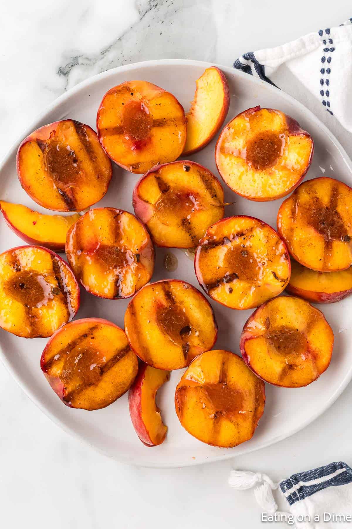 Peach halves on a plate topped with melted butter