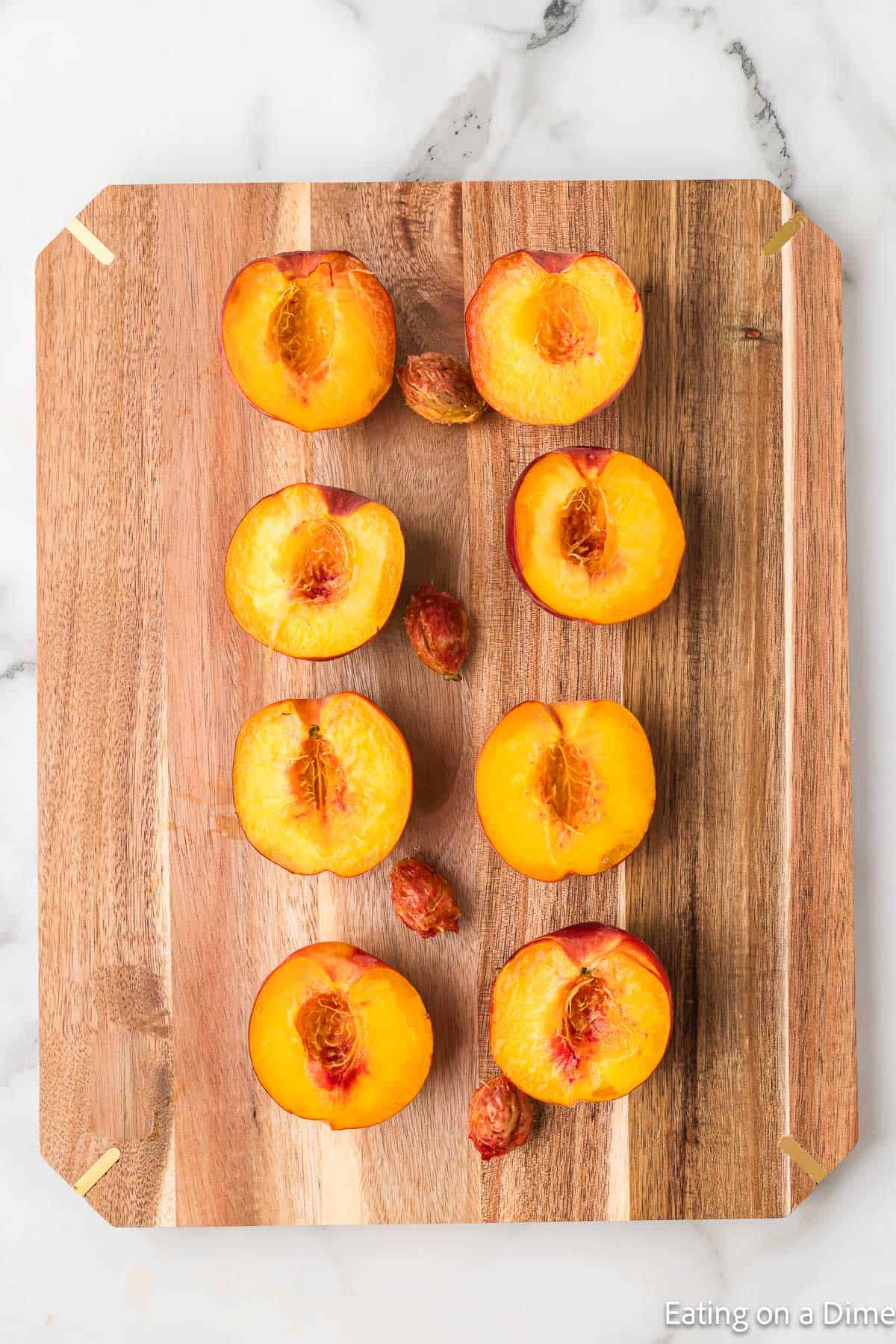 Slicing peach halves on a cutting board 