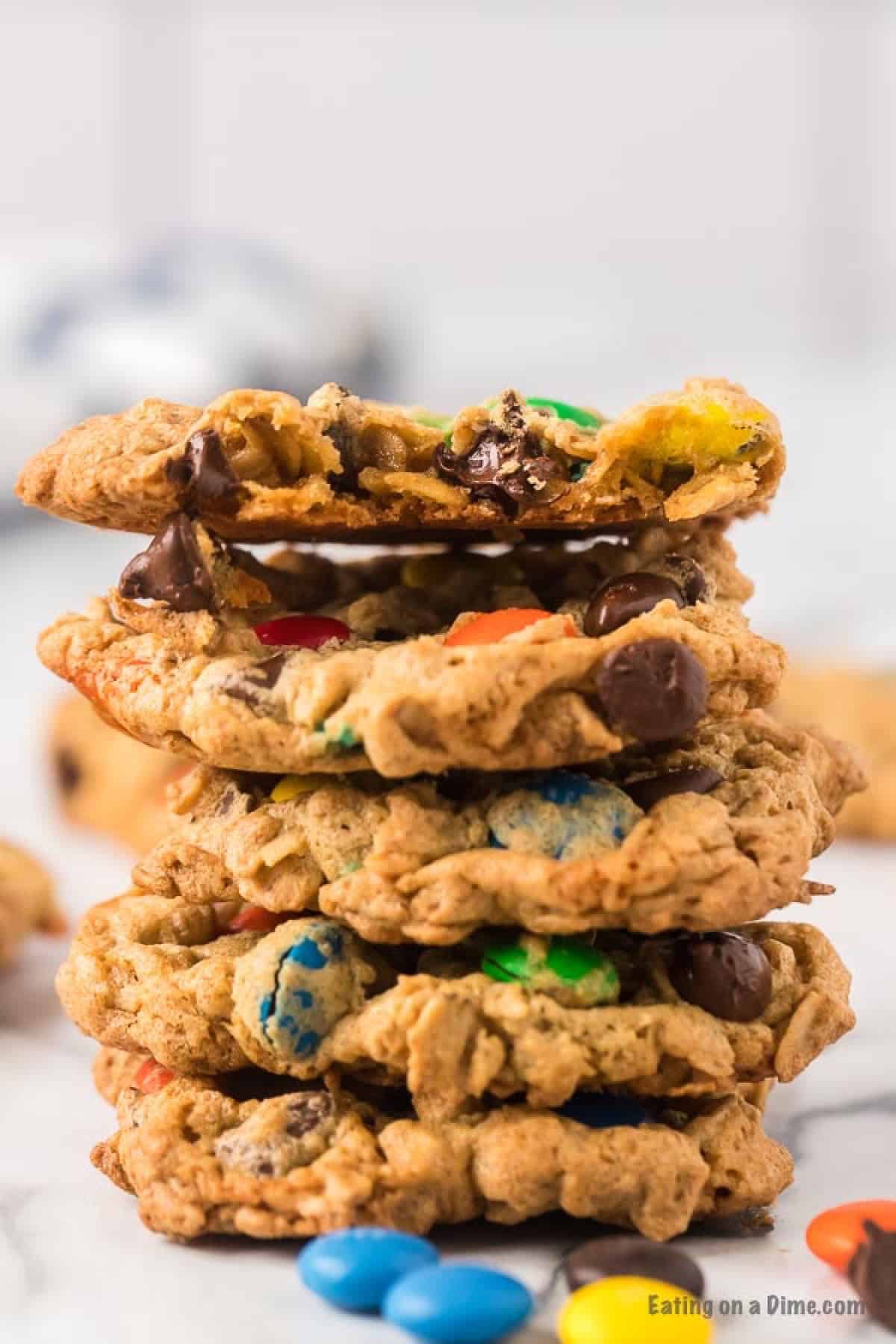 Close up image a monster cookie stacked on top of each other. There are also candy M&Ms. 