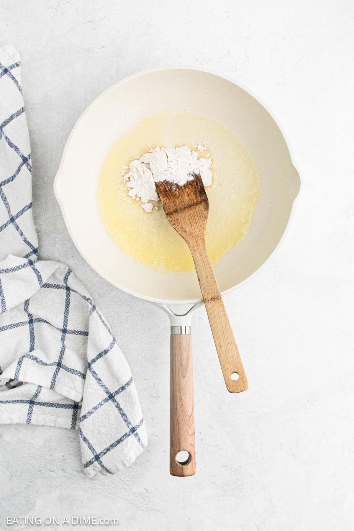 Melted butter in a skillet with flour and a wooden spoon