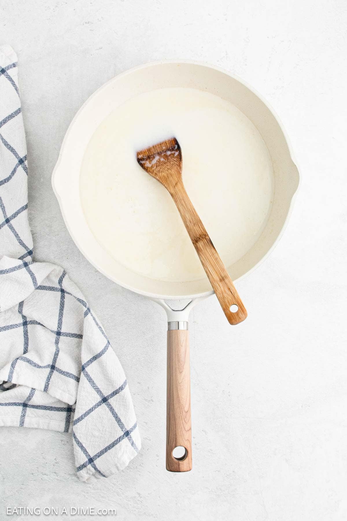 Mix in broth and milk with the melted butter in the skillet with a wooden spoon