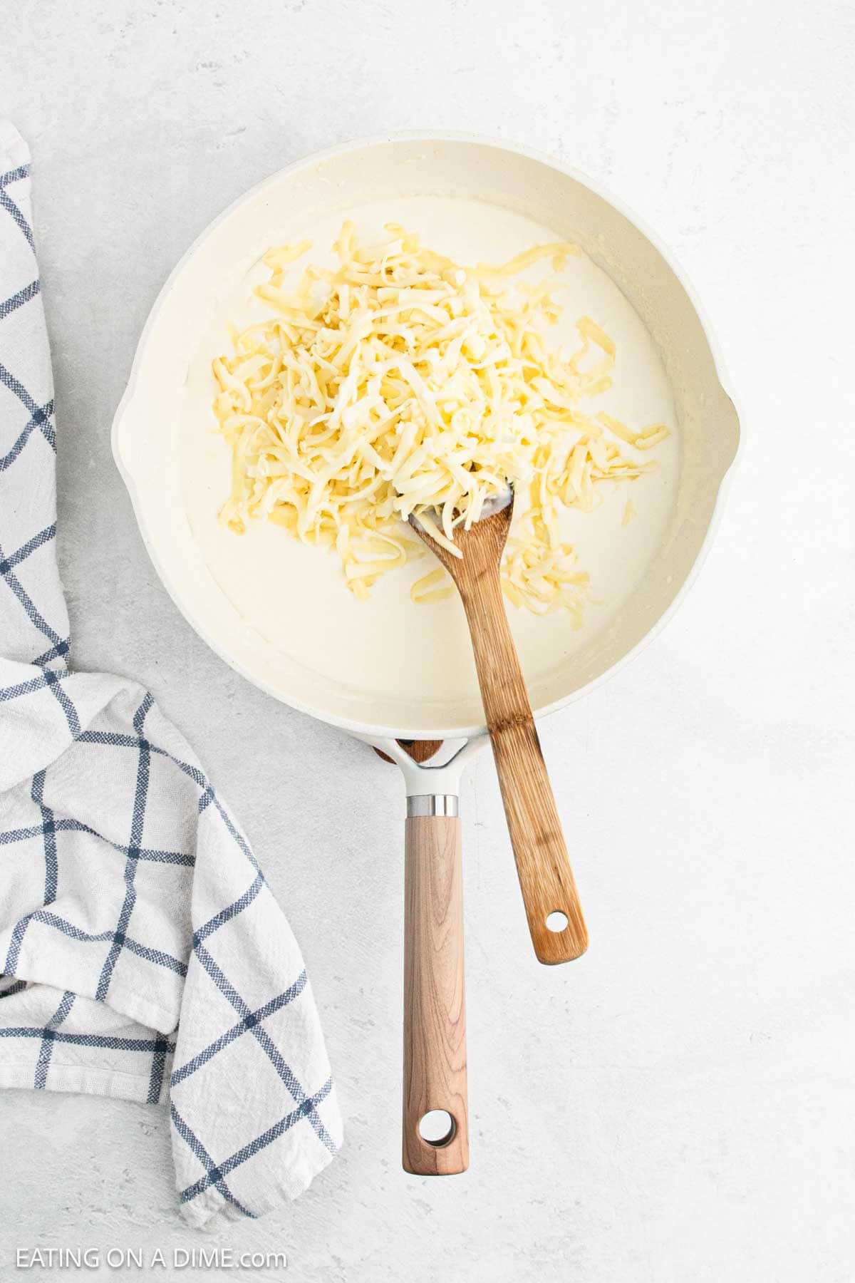 Shredded cheese topped the milk mixture in a skillet