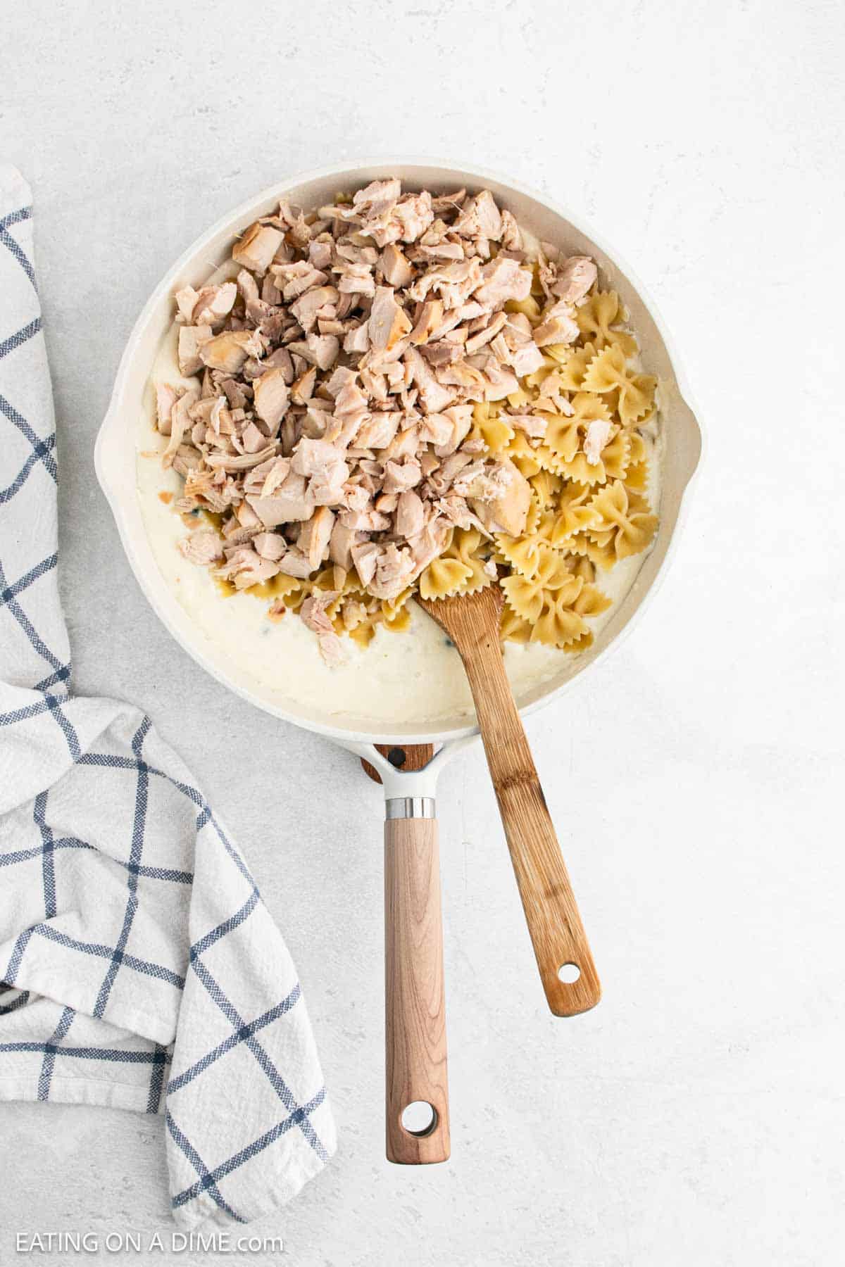 Cooked diced chicken and pasta mixed into the cream cheese mixture in the skillet