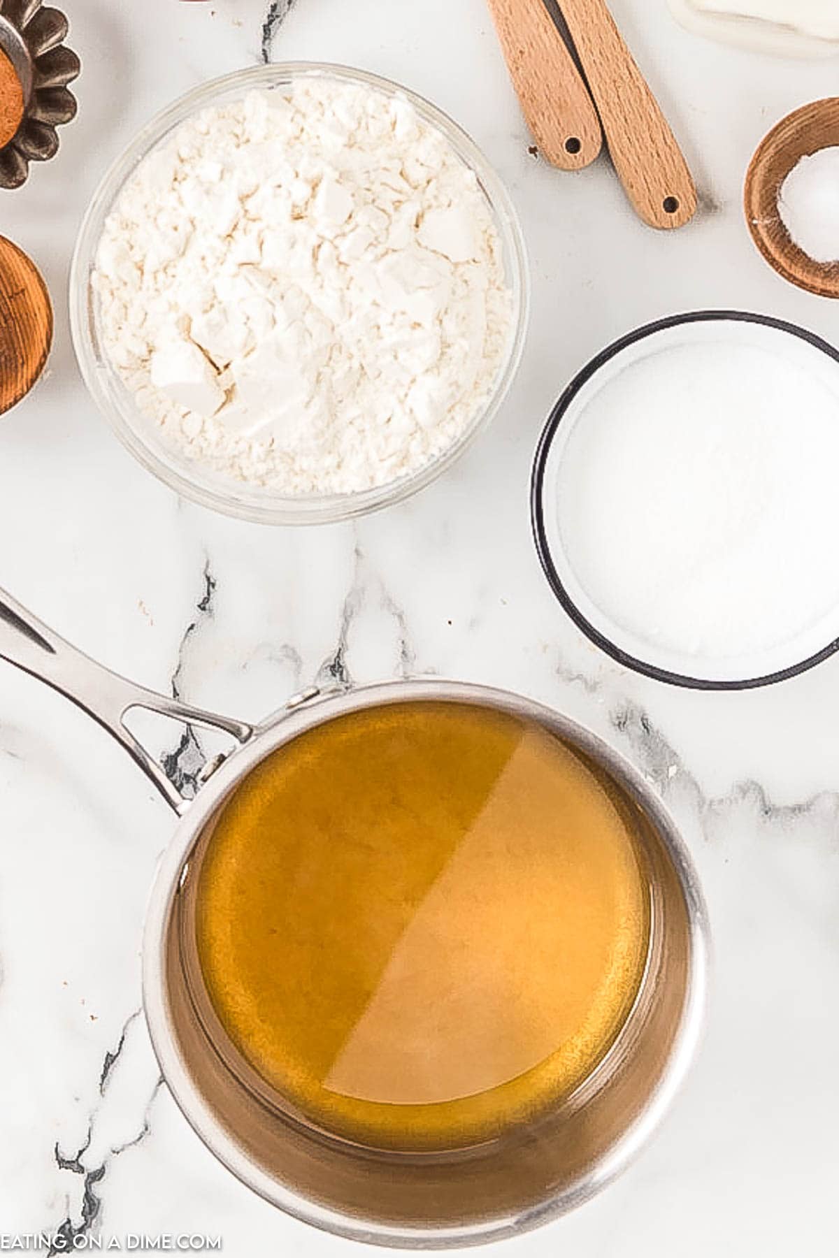 Simmering apple cider in a saucepan with bowls of flour and milk