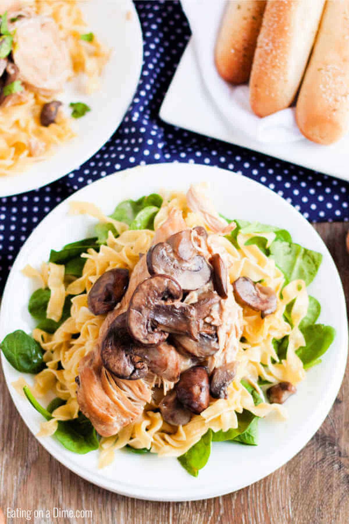 plate of chicken marsala with pasta and spinach