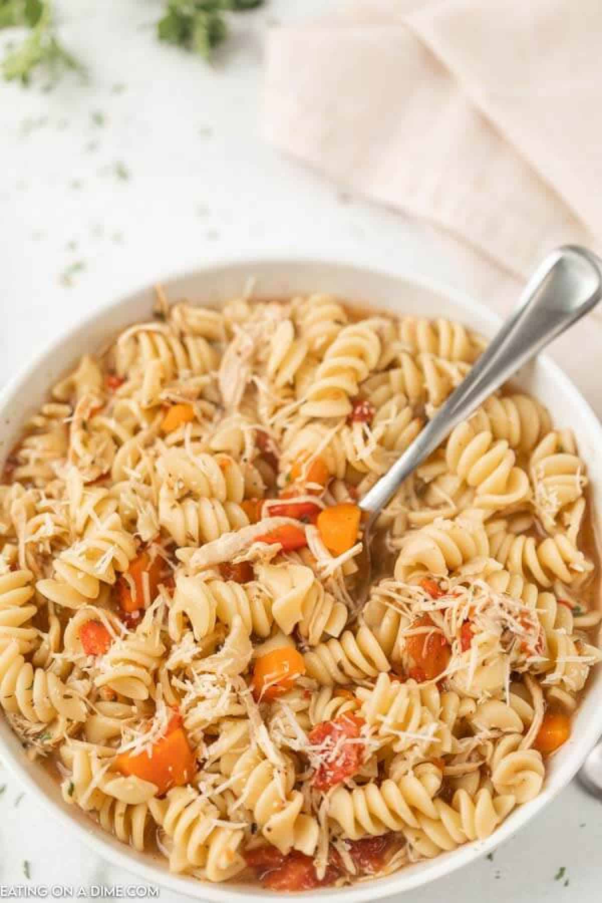 Close up image of a bowl of Italian Chicken Soup with a silver spoon in the bowl. 