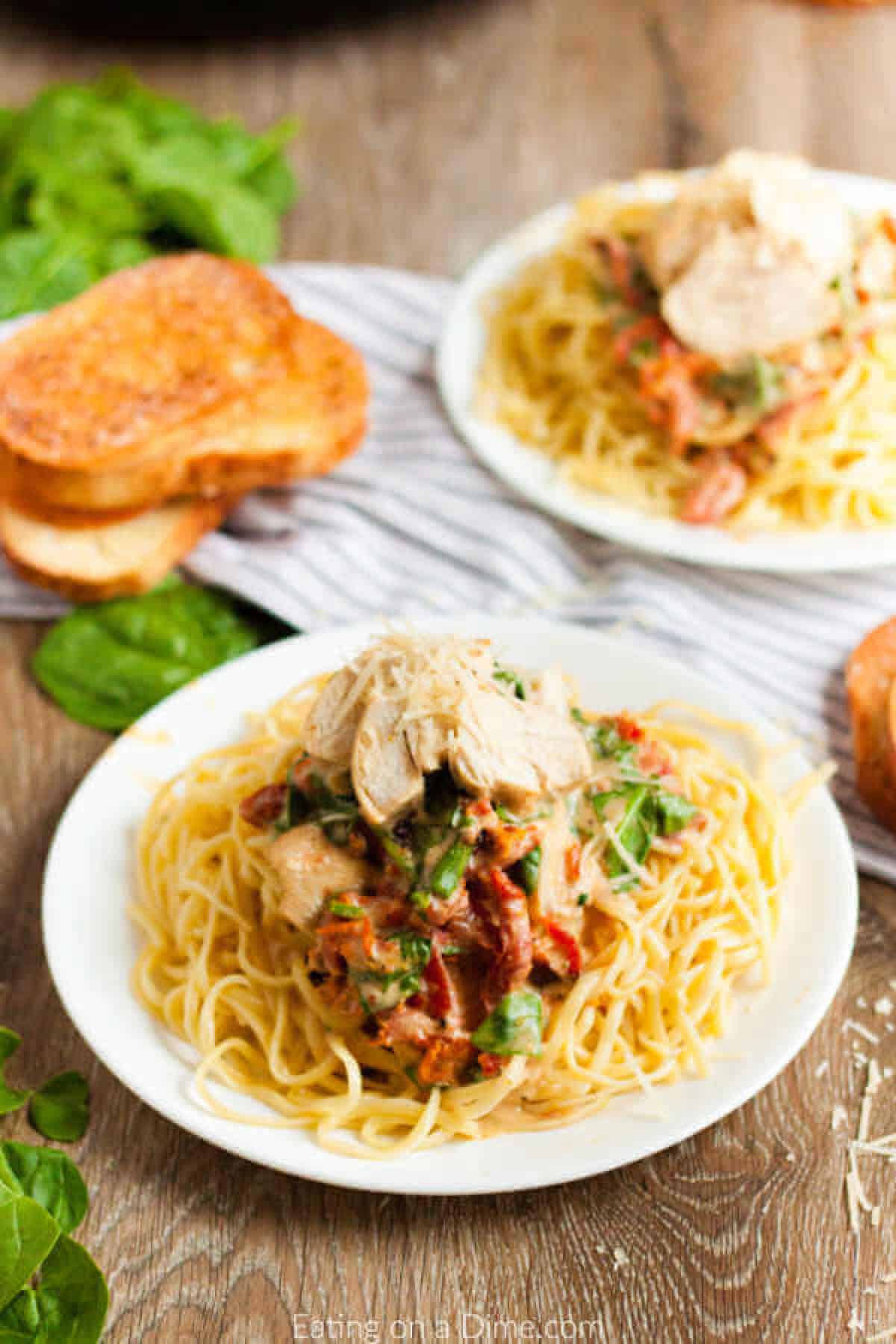 Close up image of a plate of Tuscan Chicken on pasta. 