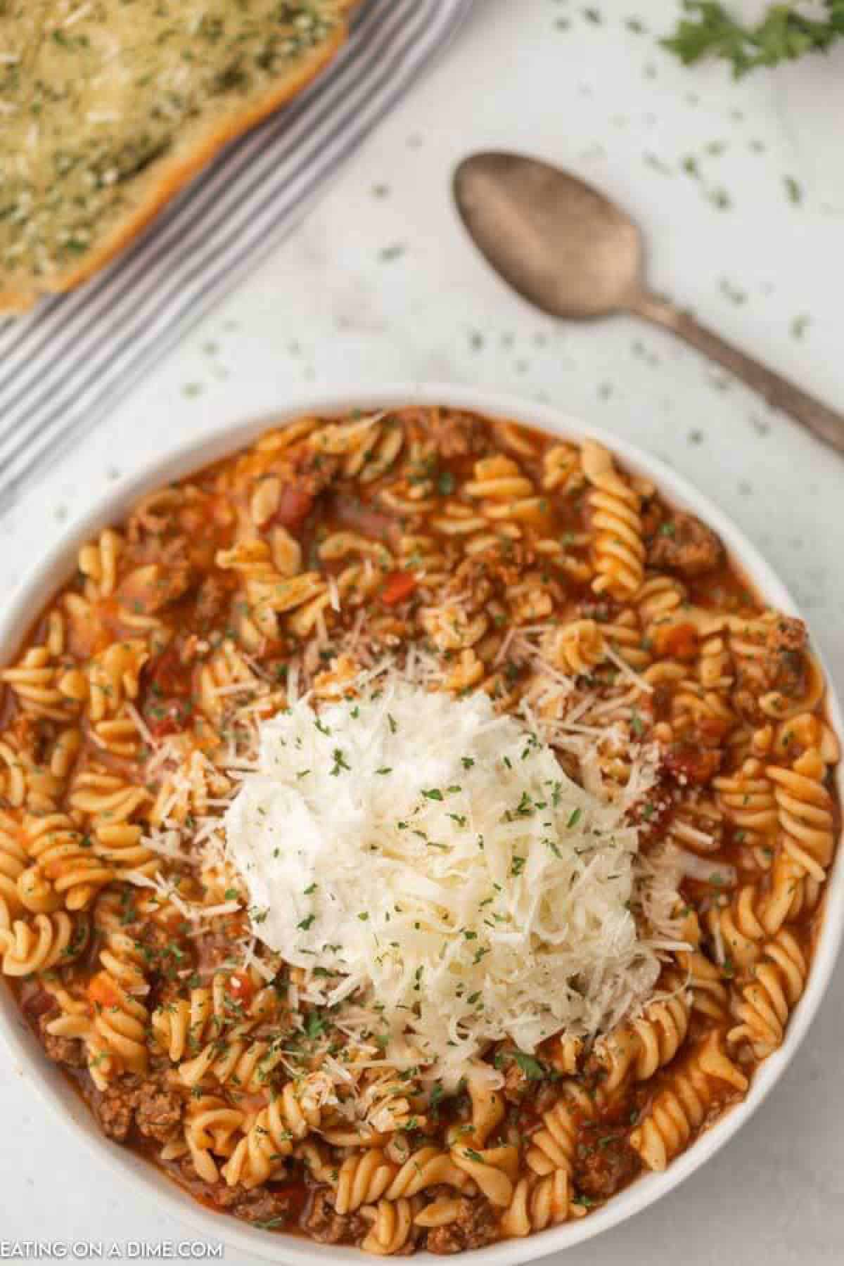 bowl of lasagna soup with a slice of french bread and spoon. 