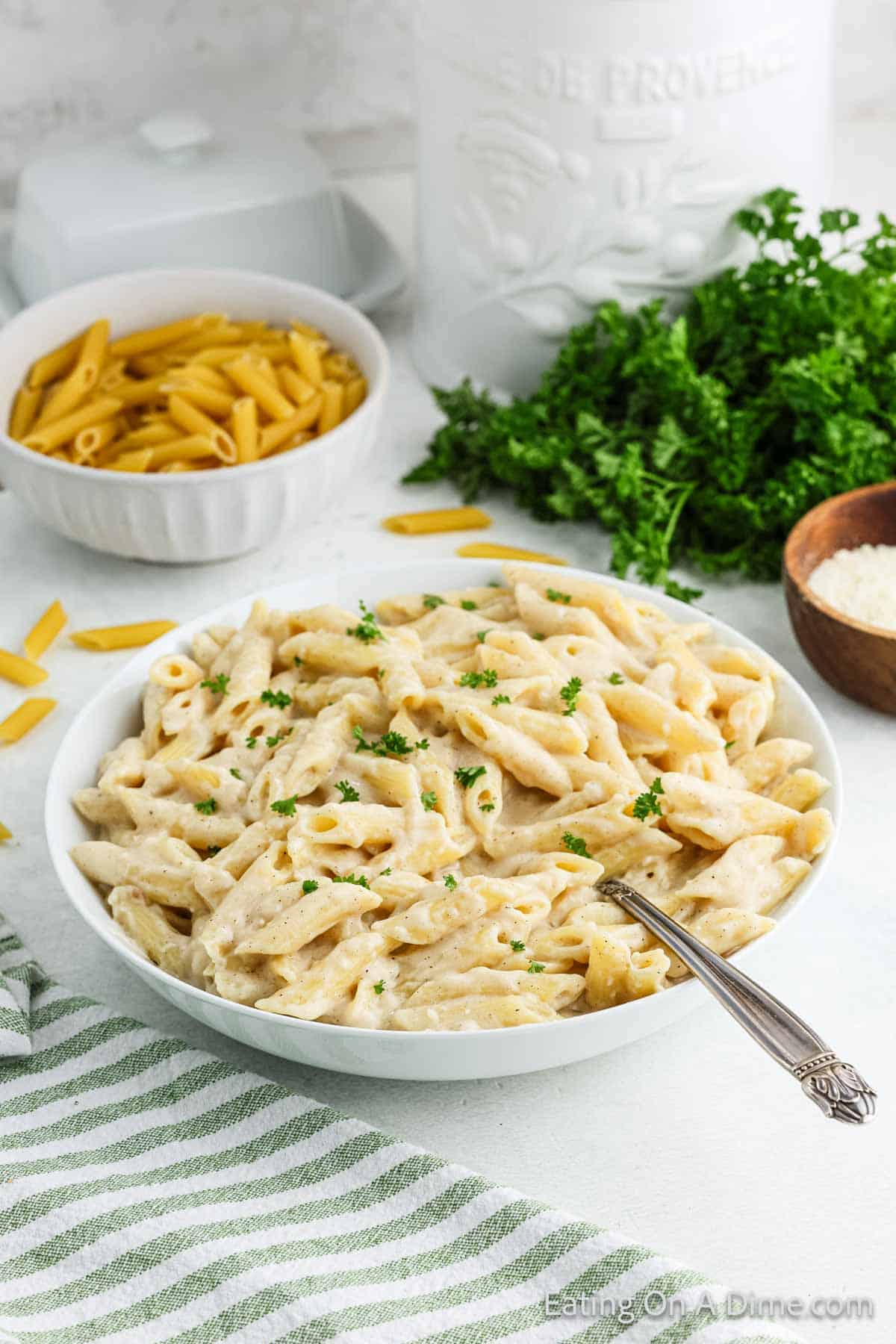 Penne Pasta in a bowl topped with white pasta sauce 