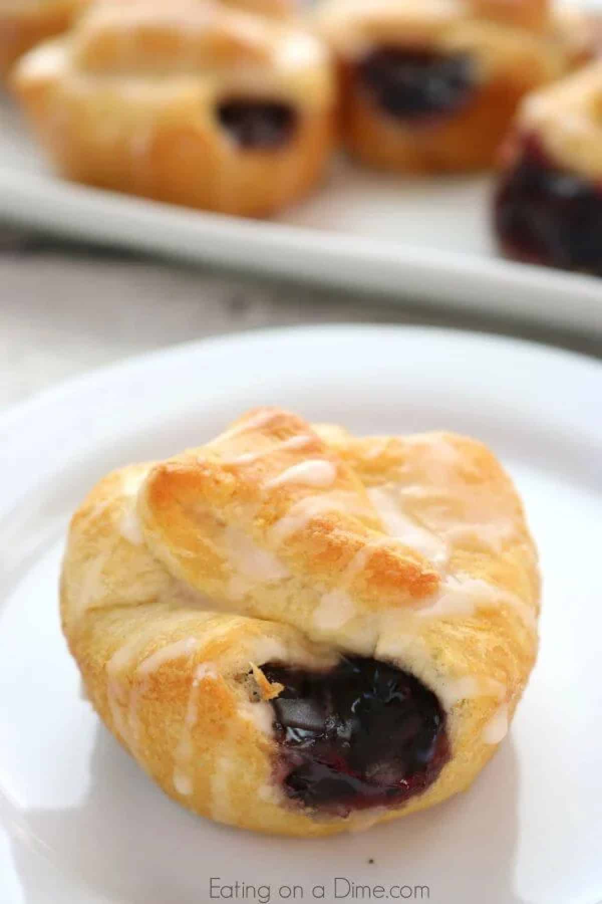 Mini blueberry pie bite on a white plate. 