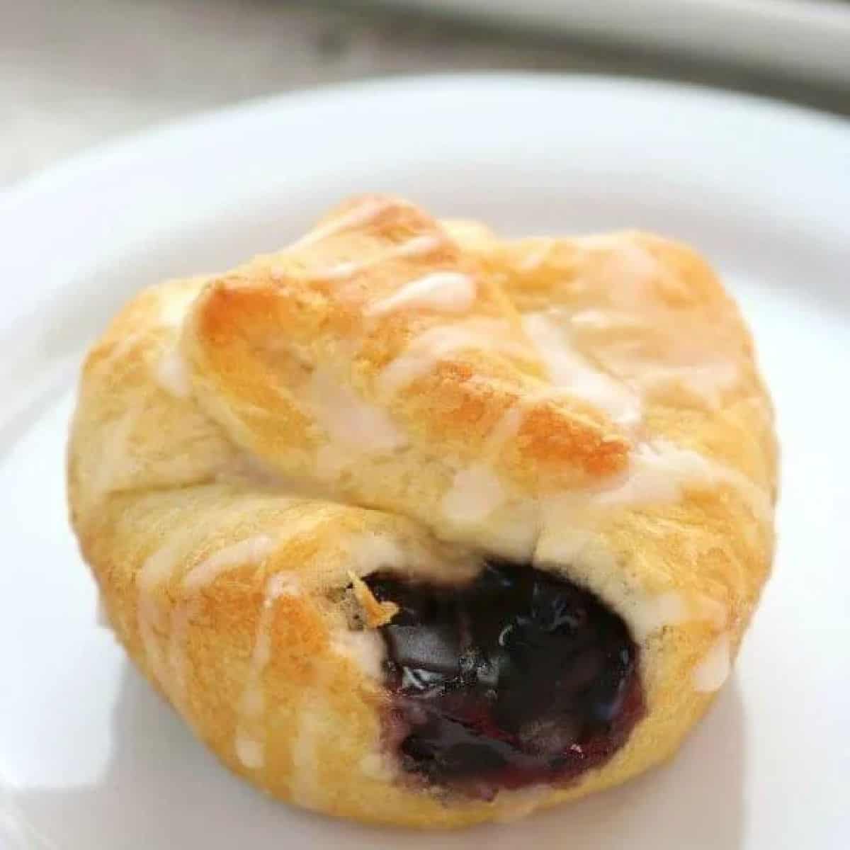 Mini blueberry pie bite on a white plate. 