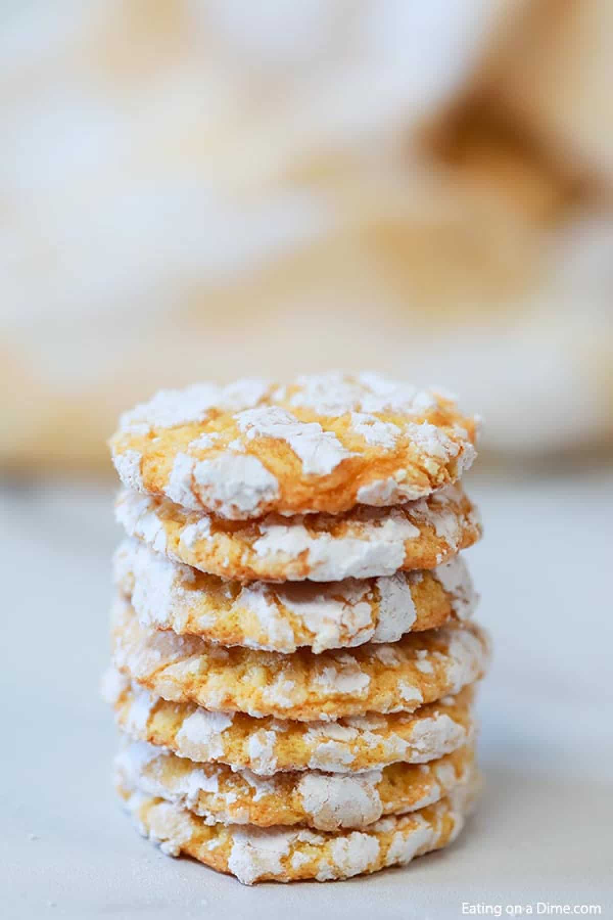 Multiple lemon crinkle cookies stacked on top of each other. 