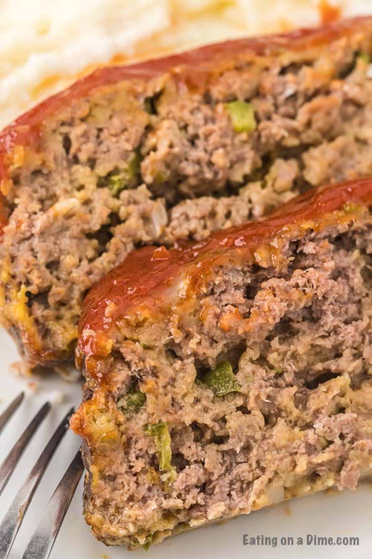 Close up image of meatloaf on a white plate. 