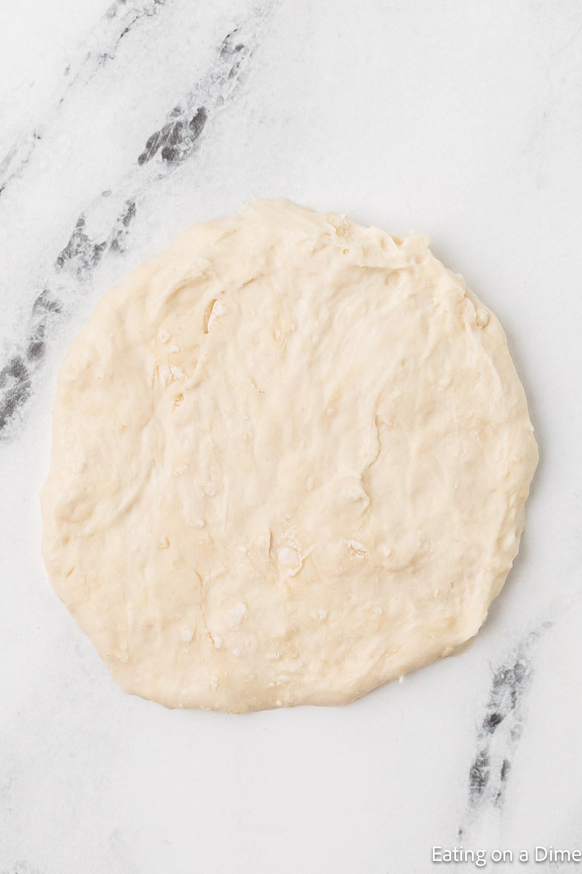 Flatten dough on a marble counter