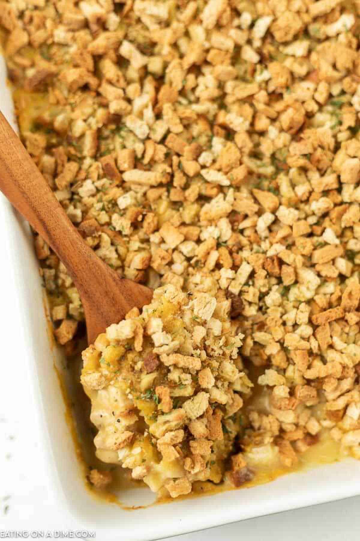 Chicken stuffing bake in casserole dish with a spoon. 