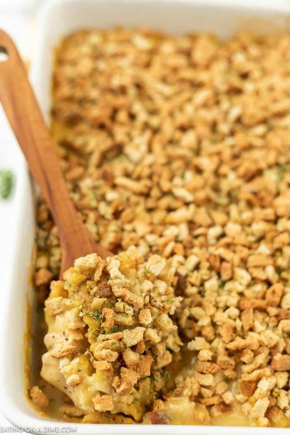 Chicken stuffing bake in casserole dish with serving spoon. 