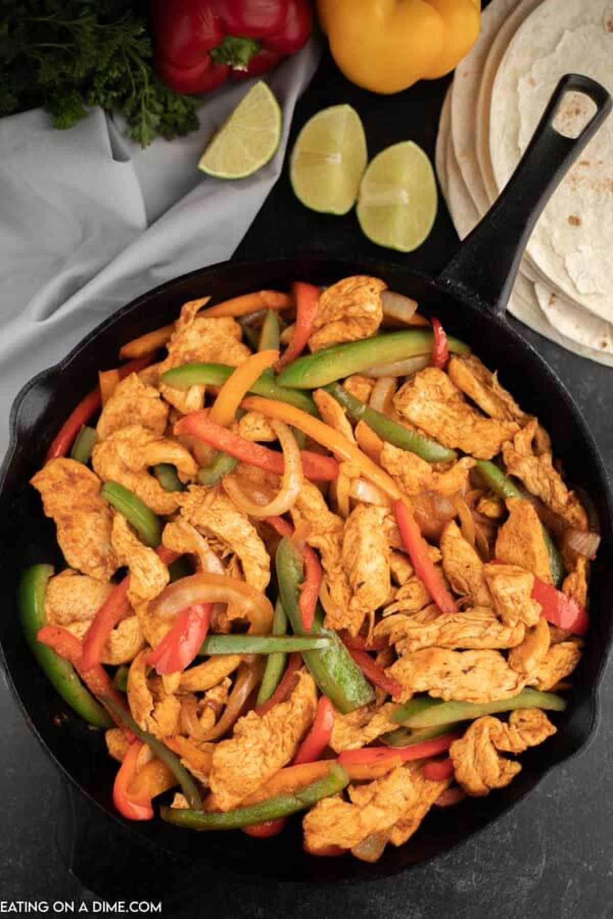  Cast iron skillet of chicken strips, bell peppers and onion. 