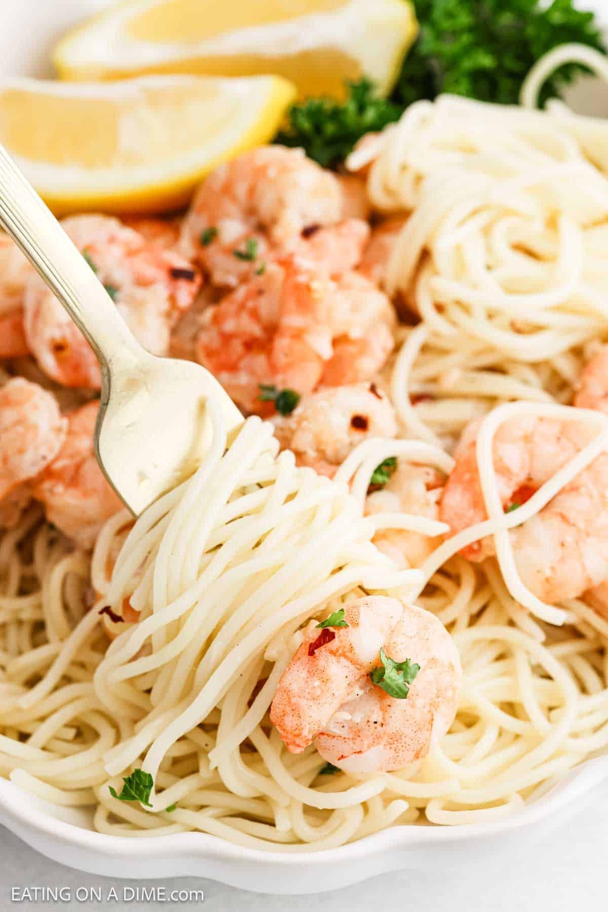 Shrimp Scampi mixed with spaghetti noodles with a bite on a fork