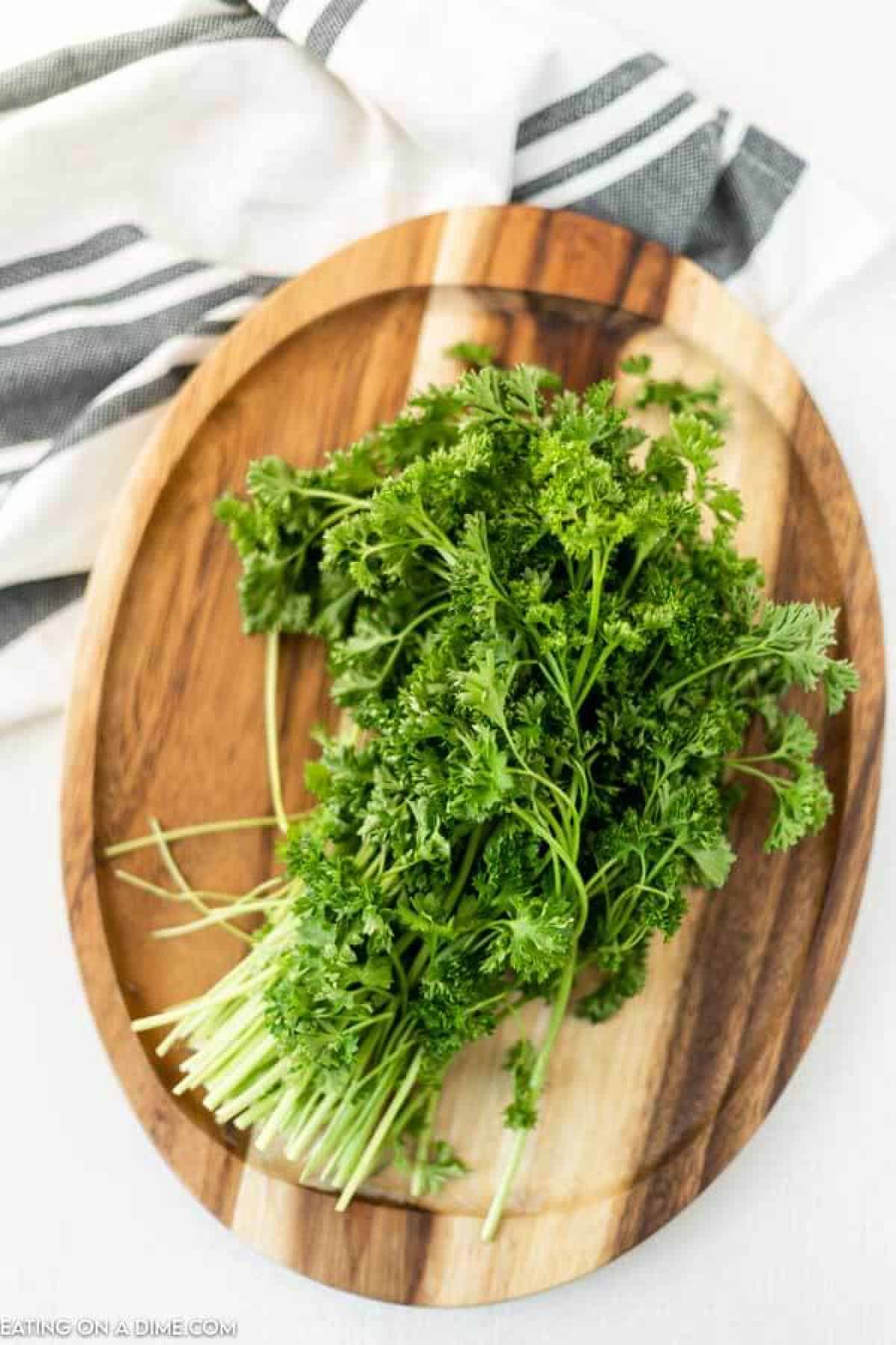 Fresh parsley bundled on a cutting board. 