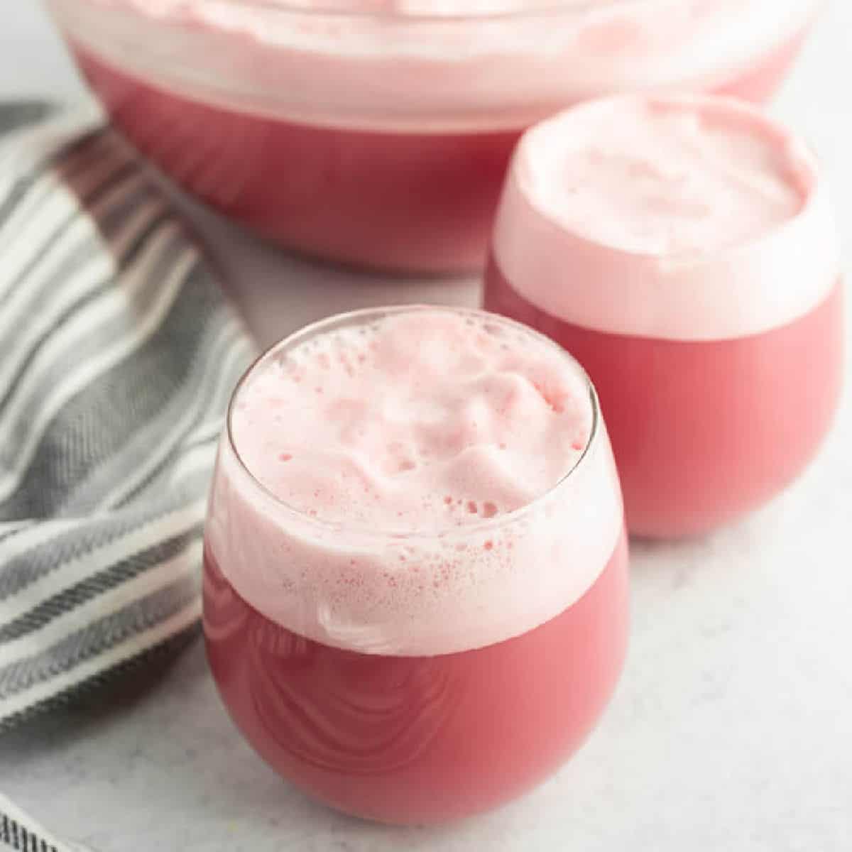 Close up image raspberry sherbet in two glasses and in a punch bowl. 