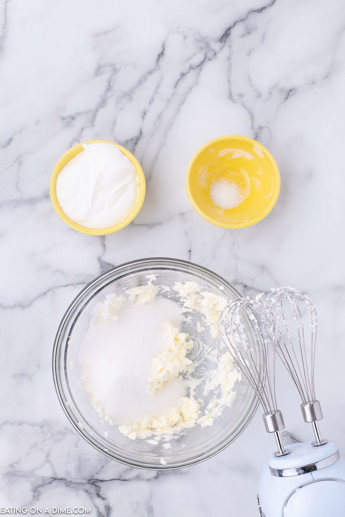 Butter, sour cream and sugar mixed together in a bowl with a hand mixer