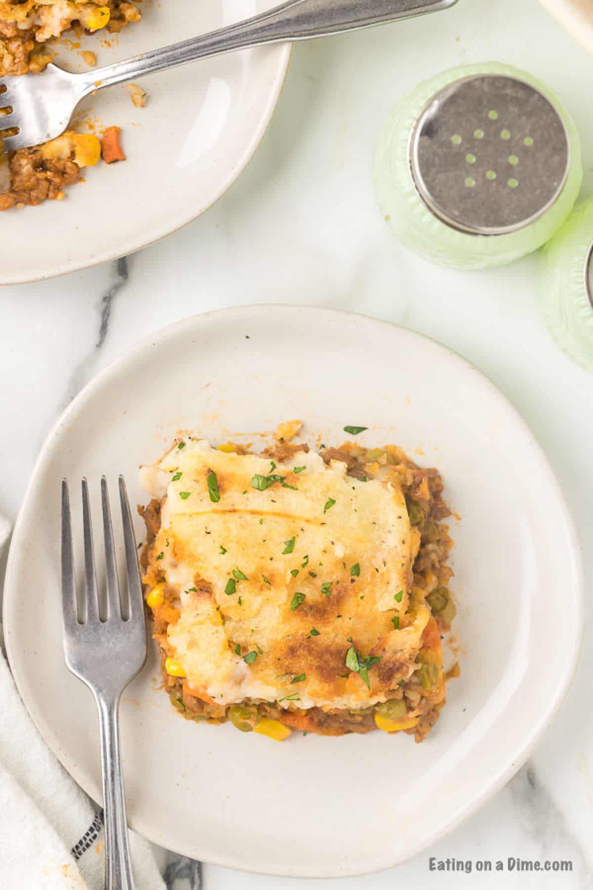 Close up image of Shepherd's Pie on a white plate with a fork. 