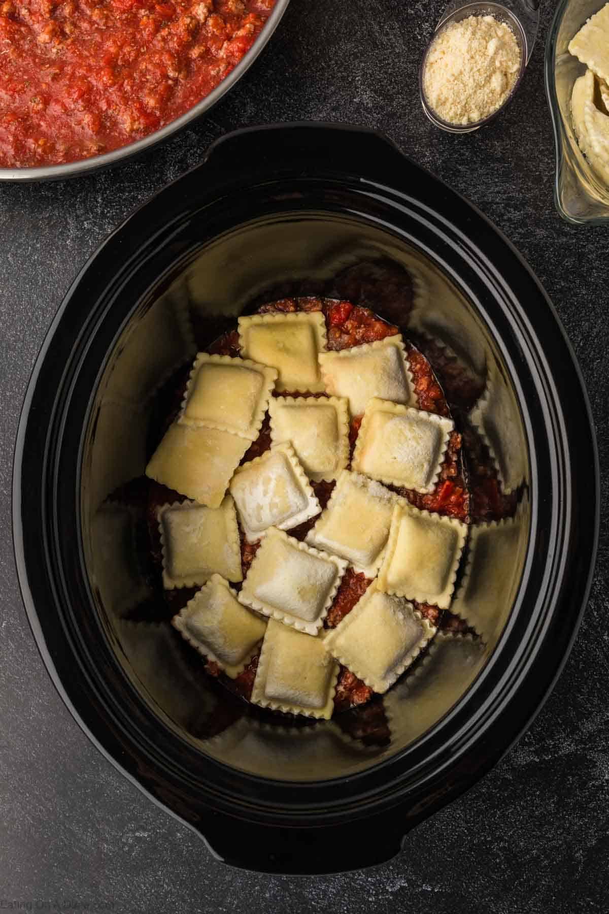 Frozen Ravioli layered on top of the ground beef mixture in the slow cooker