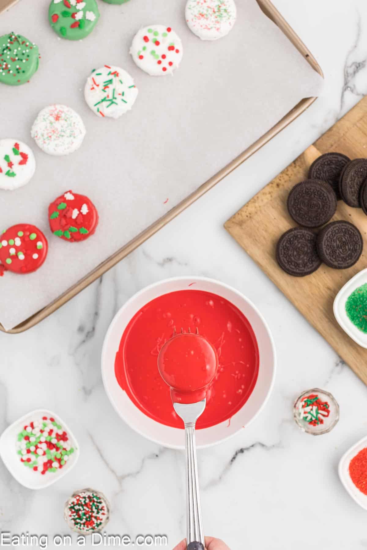 Melted Red Melts in a small bowl with a red coated Oreos on a fork 