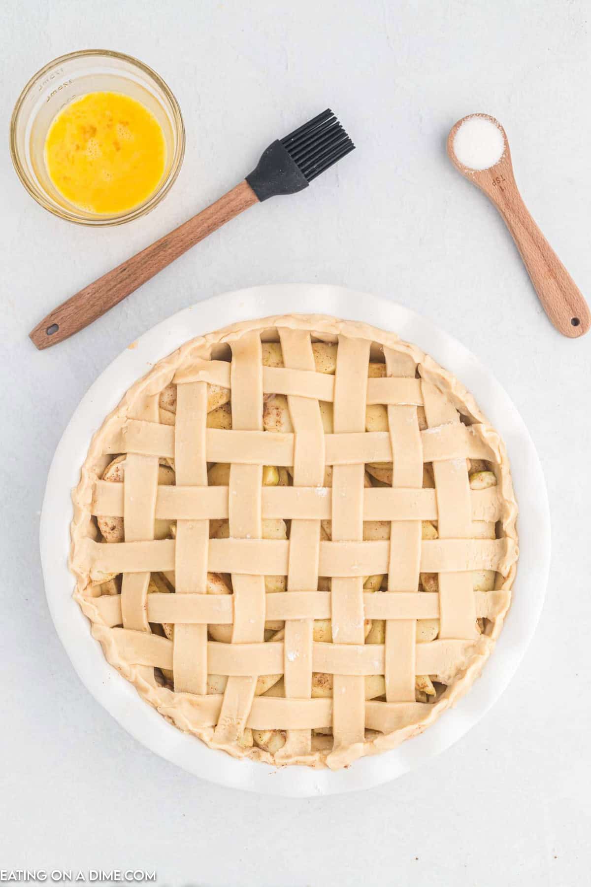 Strips are weaved to make the top crust over the slice apples in a pie plate