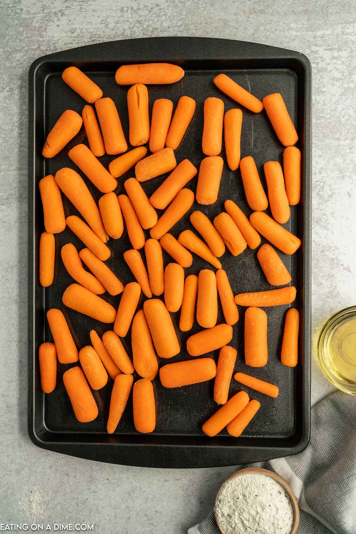 Baby carrots spread on a baking sheet