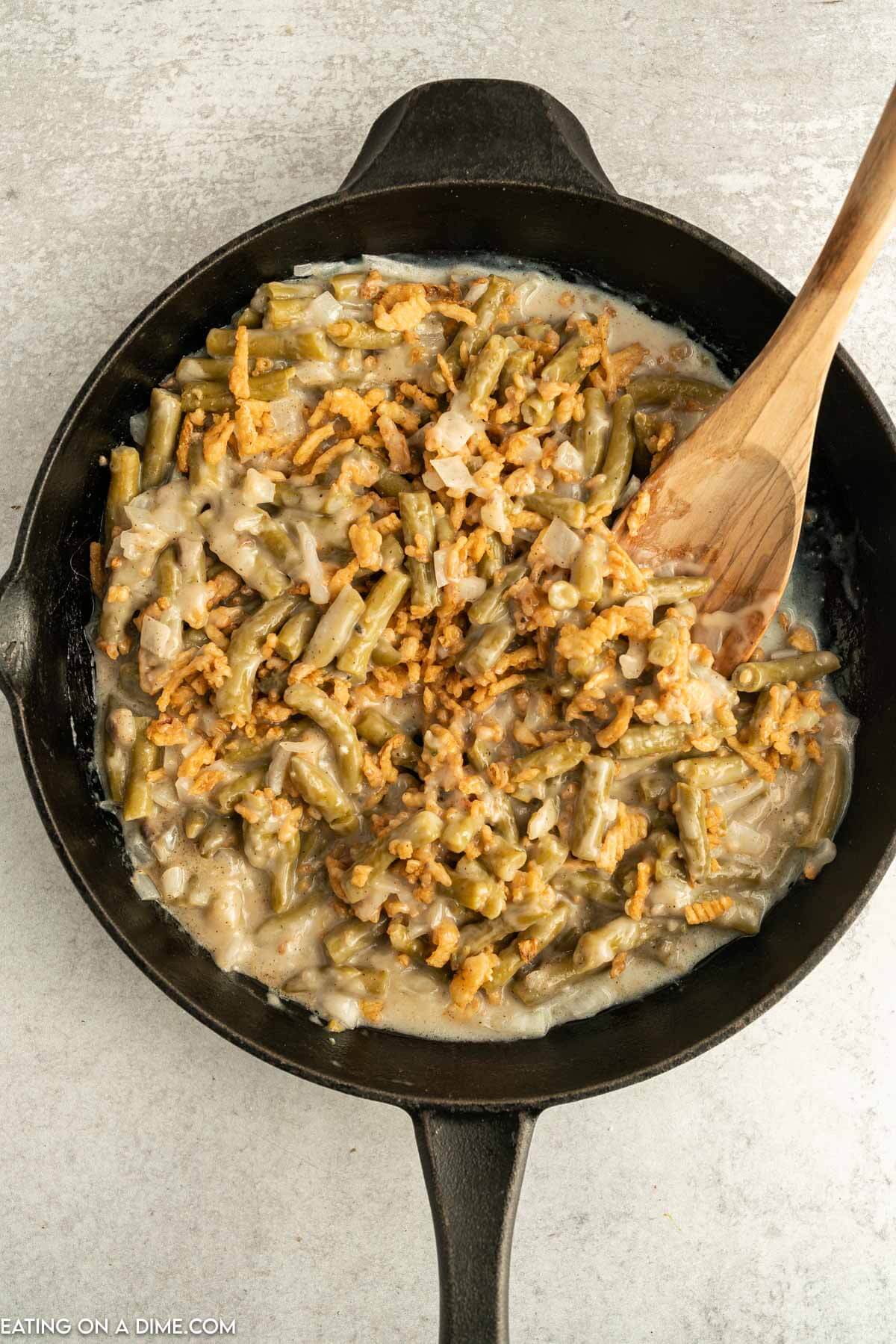 French Fried Onions mixed with the green bean mixture in a cast iron skillet