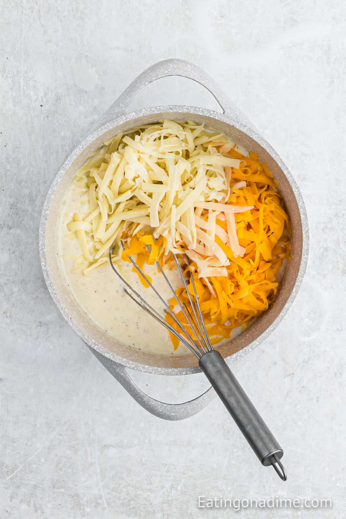 Shredded cheese added to the milk mixture in the sauce pan