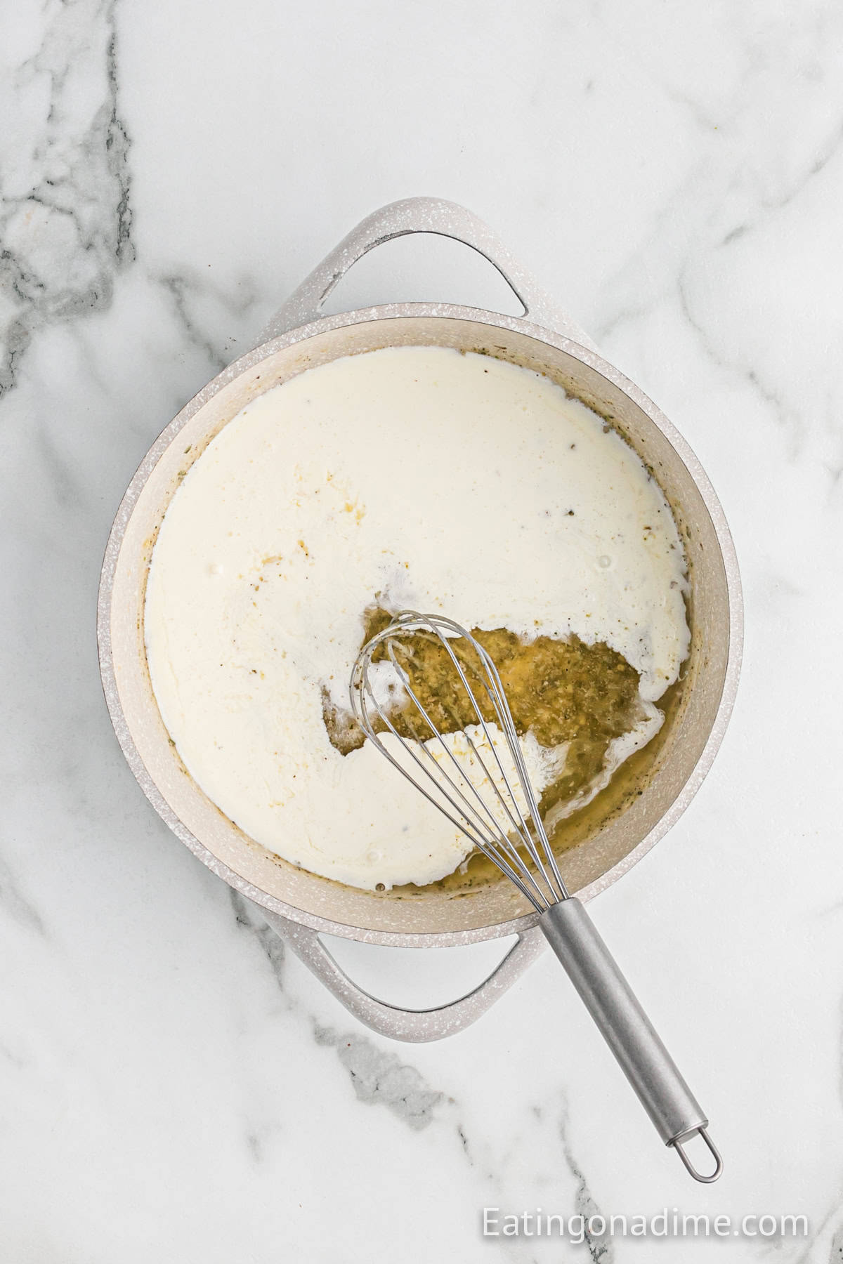 Heavy cream added to the butter mixture in the saucepan with a whisk