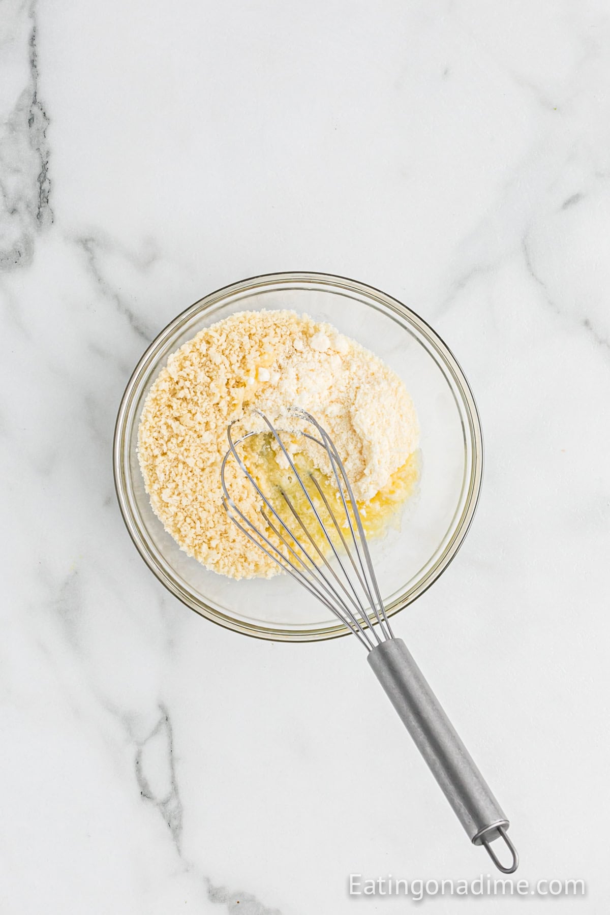 Bread crumb mixture in a bowl with a whisk