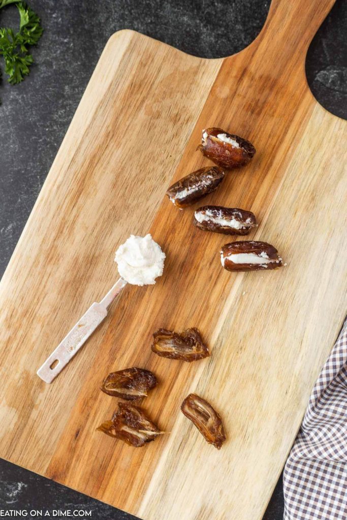 Tablespoon full of goat cheese with dates cut in half with goat cheese in the center