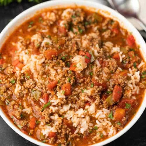 A bowl of hearty stuffed pepper soup, rich in ground beef, diced tomatoes, green bell peppers, rice, and herbs, creates a colorful and comforting dish when prepared with the Instant Pot. Perfectly crafted for cozy meals on a dark surface.