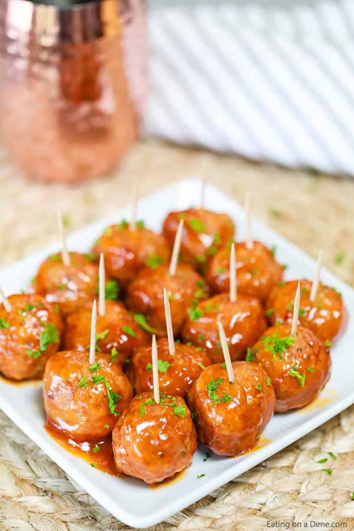 Buffalo Chicken Meatballs with toothpicks in them on a white platter