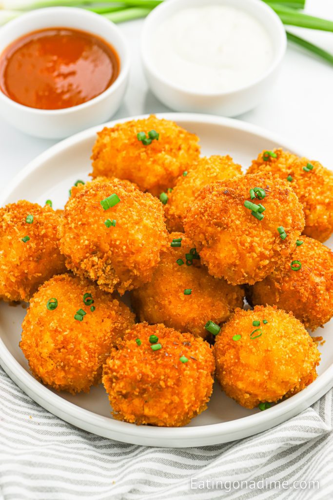 Fried Mac and Cheese balls on a plate with a side of ranch and pizza sauce in bowls