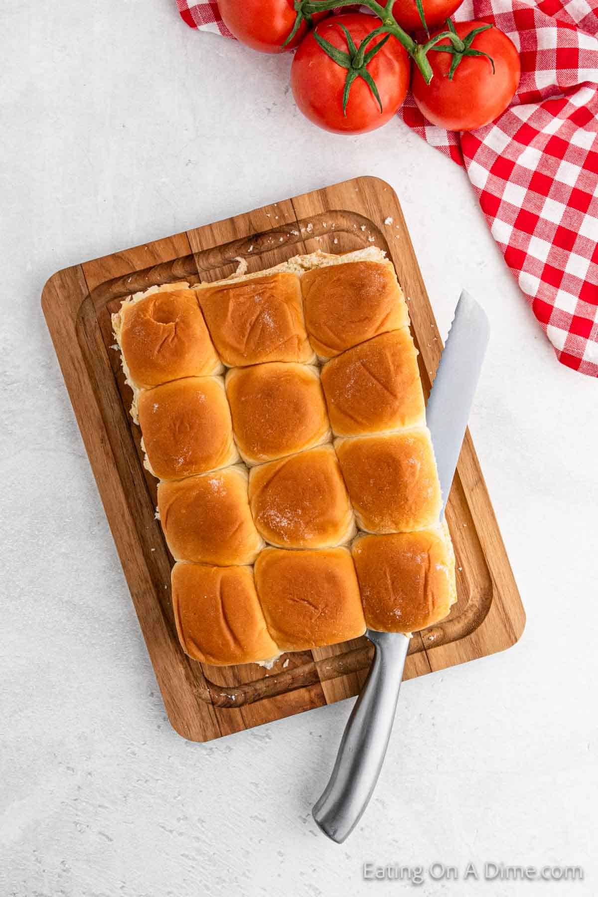 Slicing the Hawaiian Rolls with a knife on a cutting board