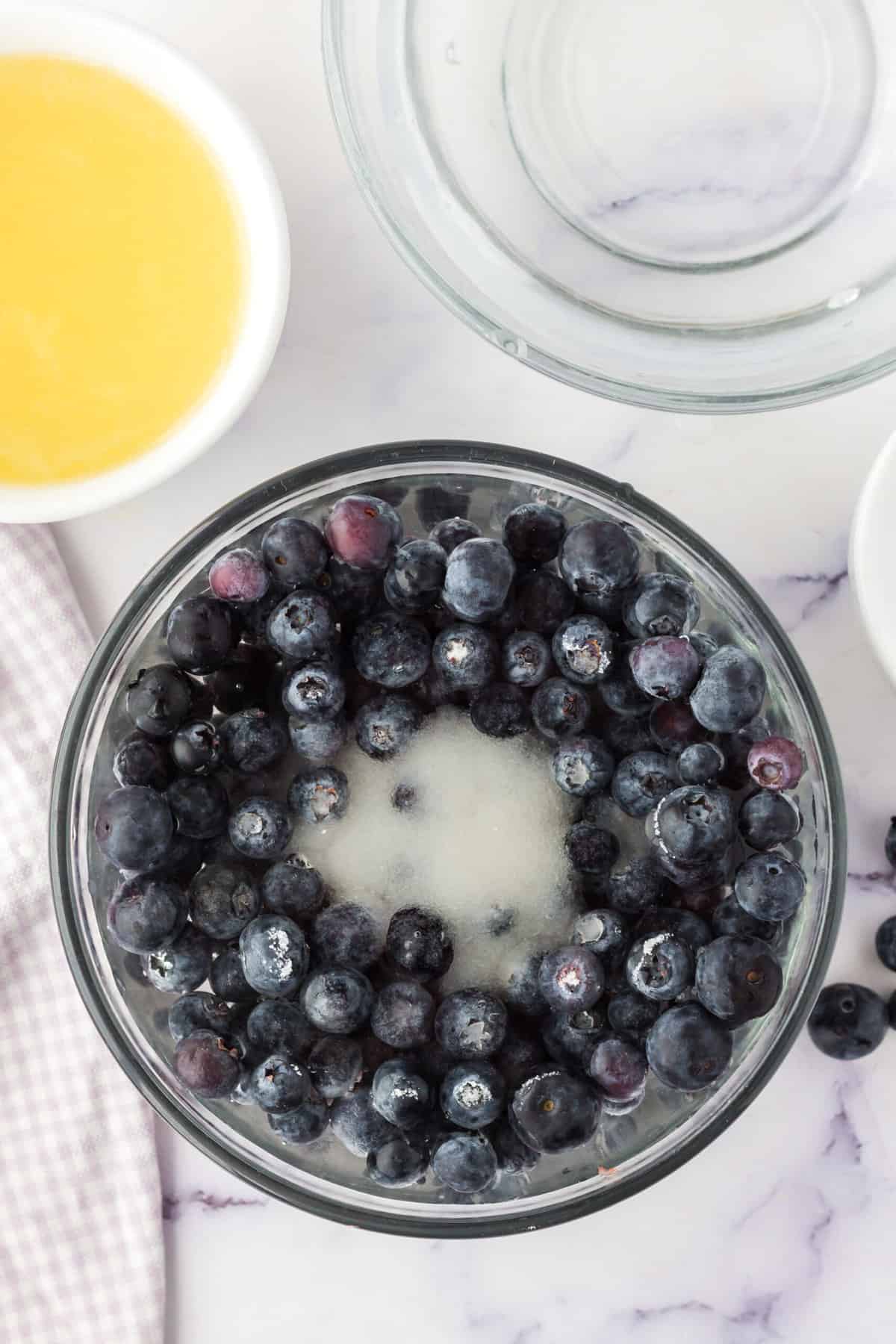 Fresh blueberries in a pitcher with sugar