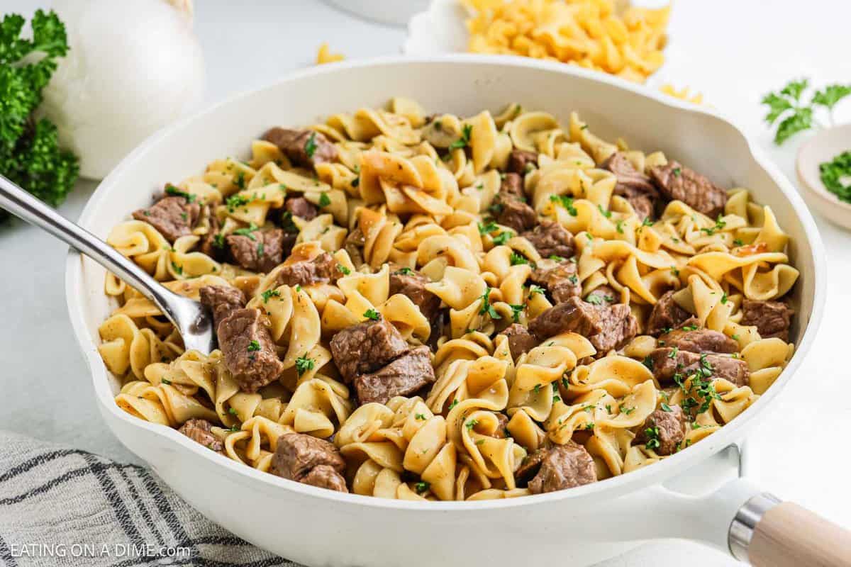 Beef Tips and noodles in a large white bowl