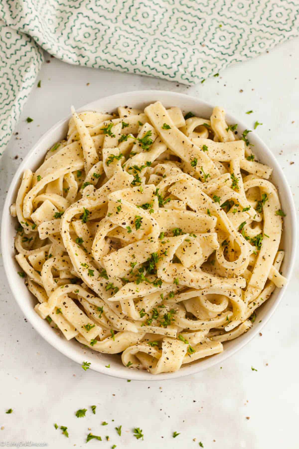 Homemade Noodles sprinkled with fresh herbs in a white bowl.