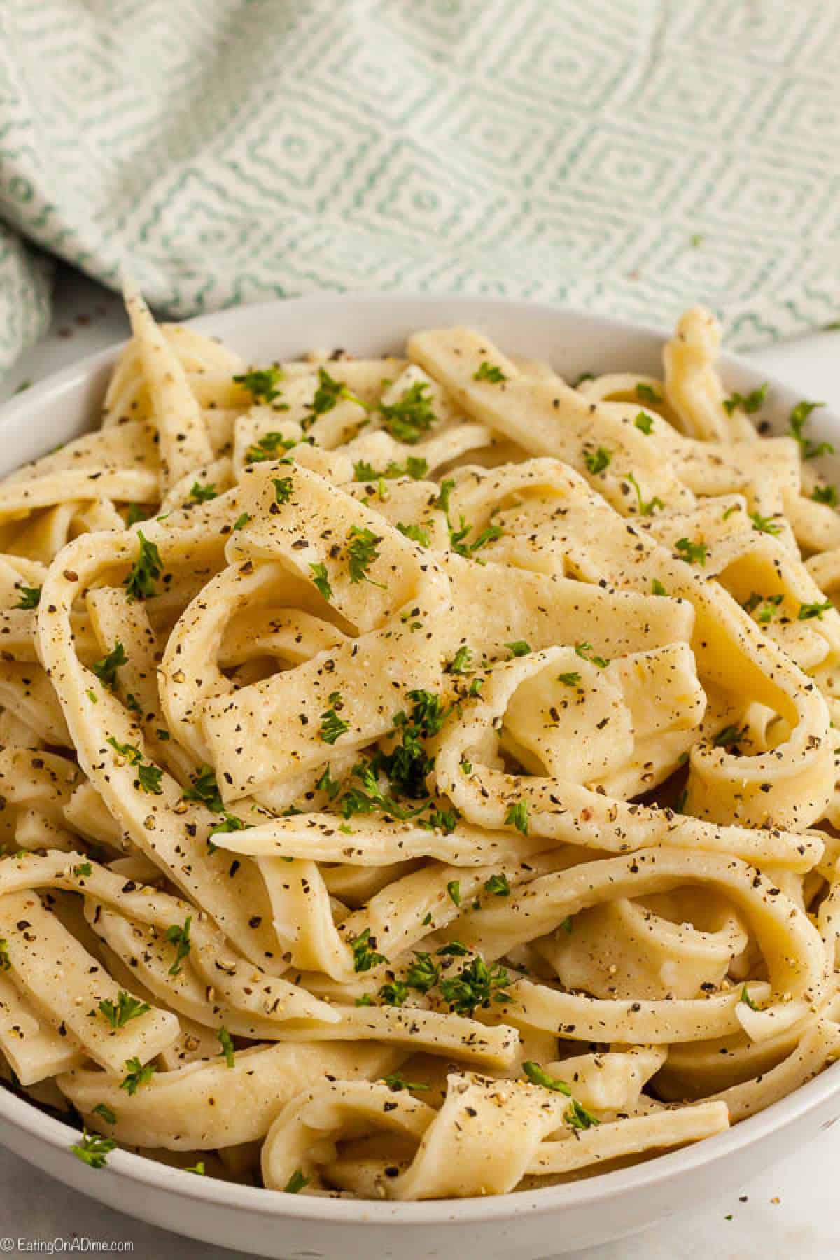 Homemade Noodles sprinkled with fresh herbs in a white bowl