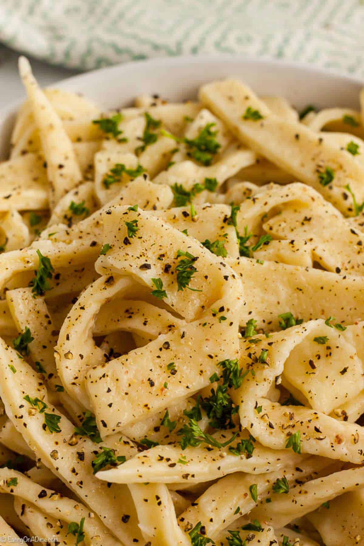 Homemade Noodles sprinkled with fresh herbs in a white bowl