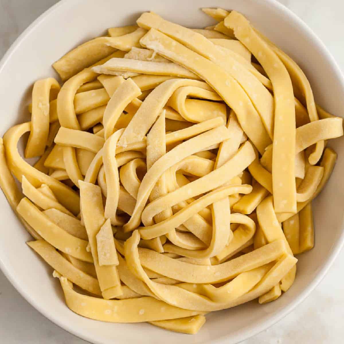 Uncooked egg noodles in a bowl