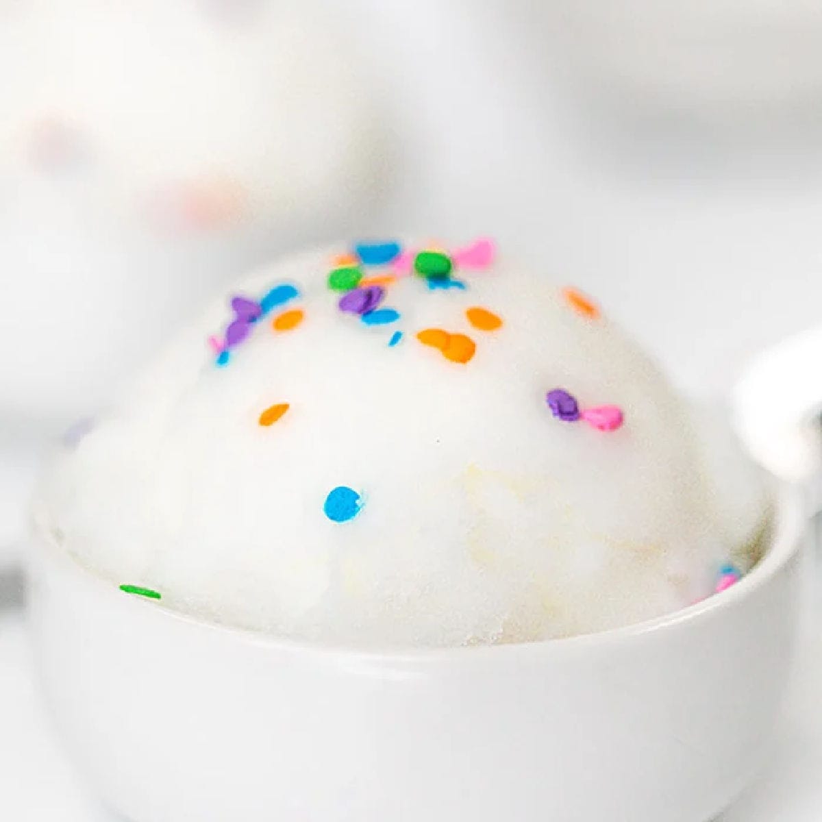  Close up image of snow ice cream in a white bowl with sprinkles on top. 