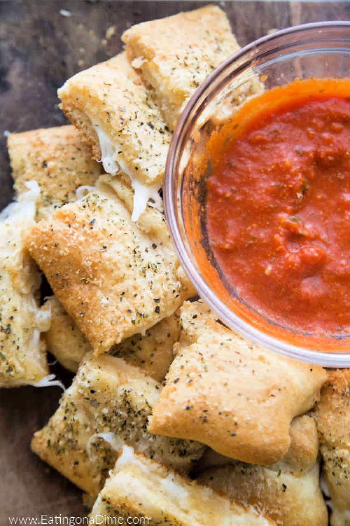 Cheesy bread stacked with a side of marinara sauce