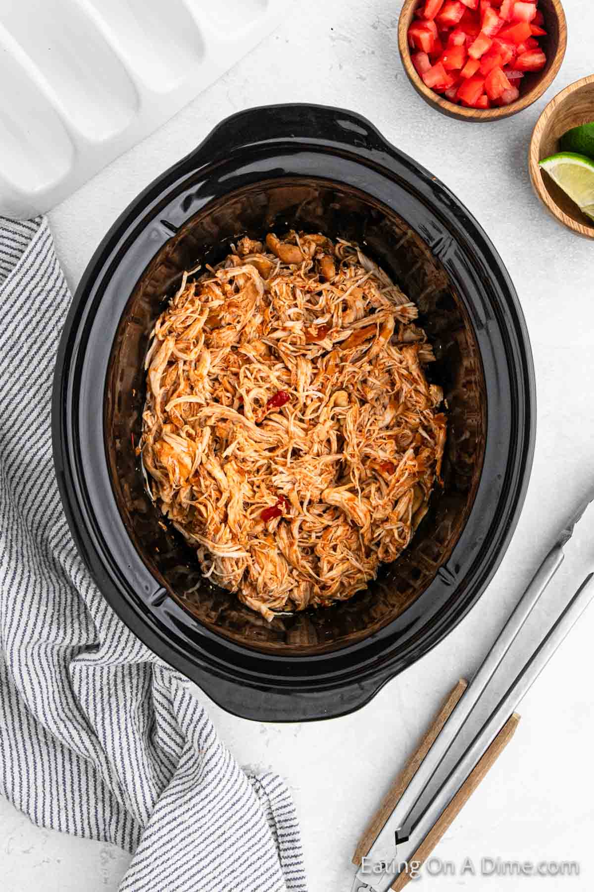 Shredded seasoned cooked chicken in the slow cooker