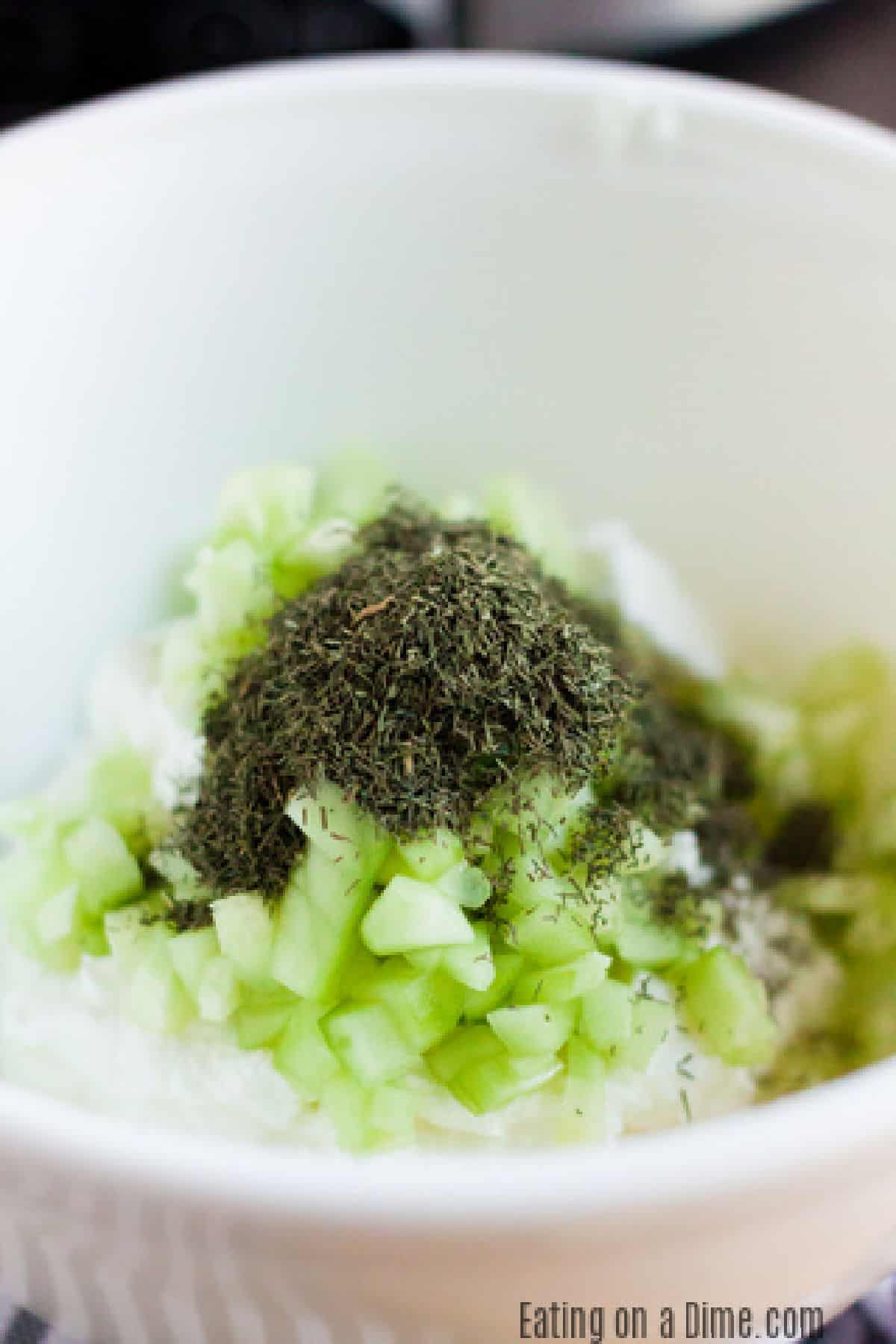 Adding the ingredients for Tzatziki Sauce in a bowl